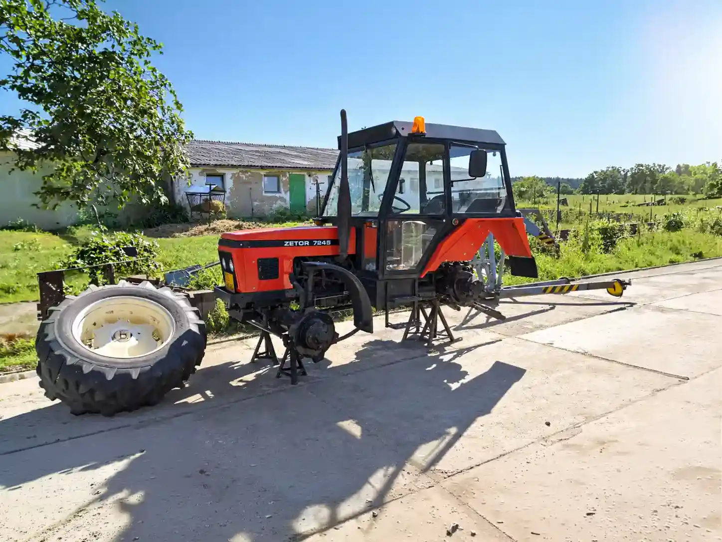 Traktor Zetor zvednutý na stojanech připravený k opravě